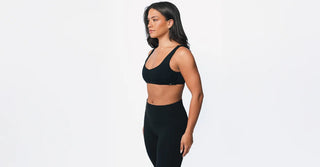 Woman in black TENCEL activewear on clean white background