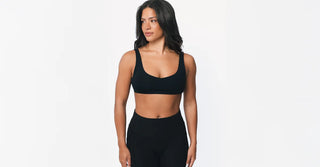 Woman in black TENCEL activewear on clean white background