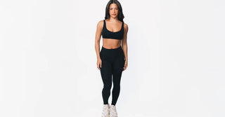 Woman in black TENCEL activewear on clean white background